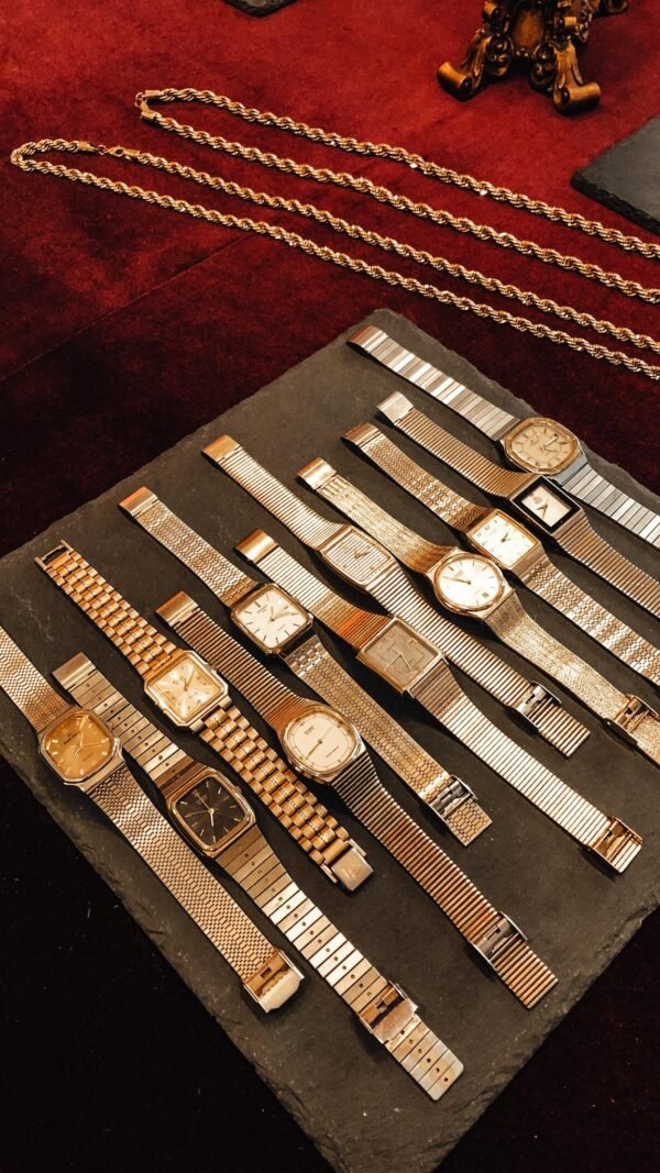 From above collection of vintage golden wrist watches placed on counter in shop