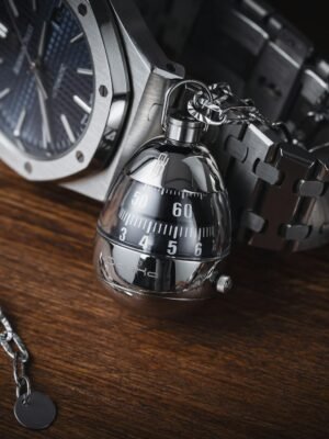 Sophisticated stainless steel watch and chain on wooden surface, highlighting elegance and luxury.